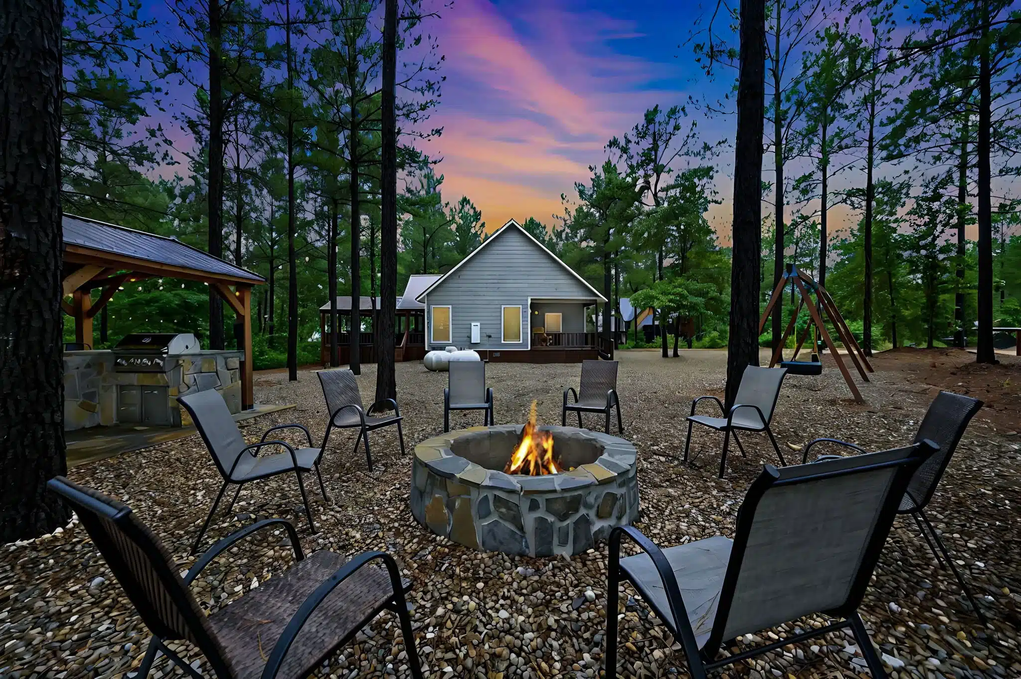 Stone fire pit with seating under pines at a Broken Bow cabin rental in Oklahoma