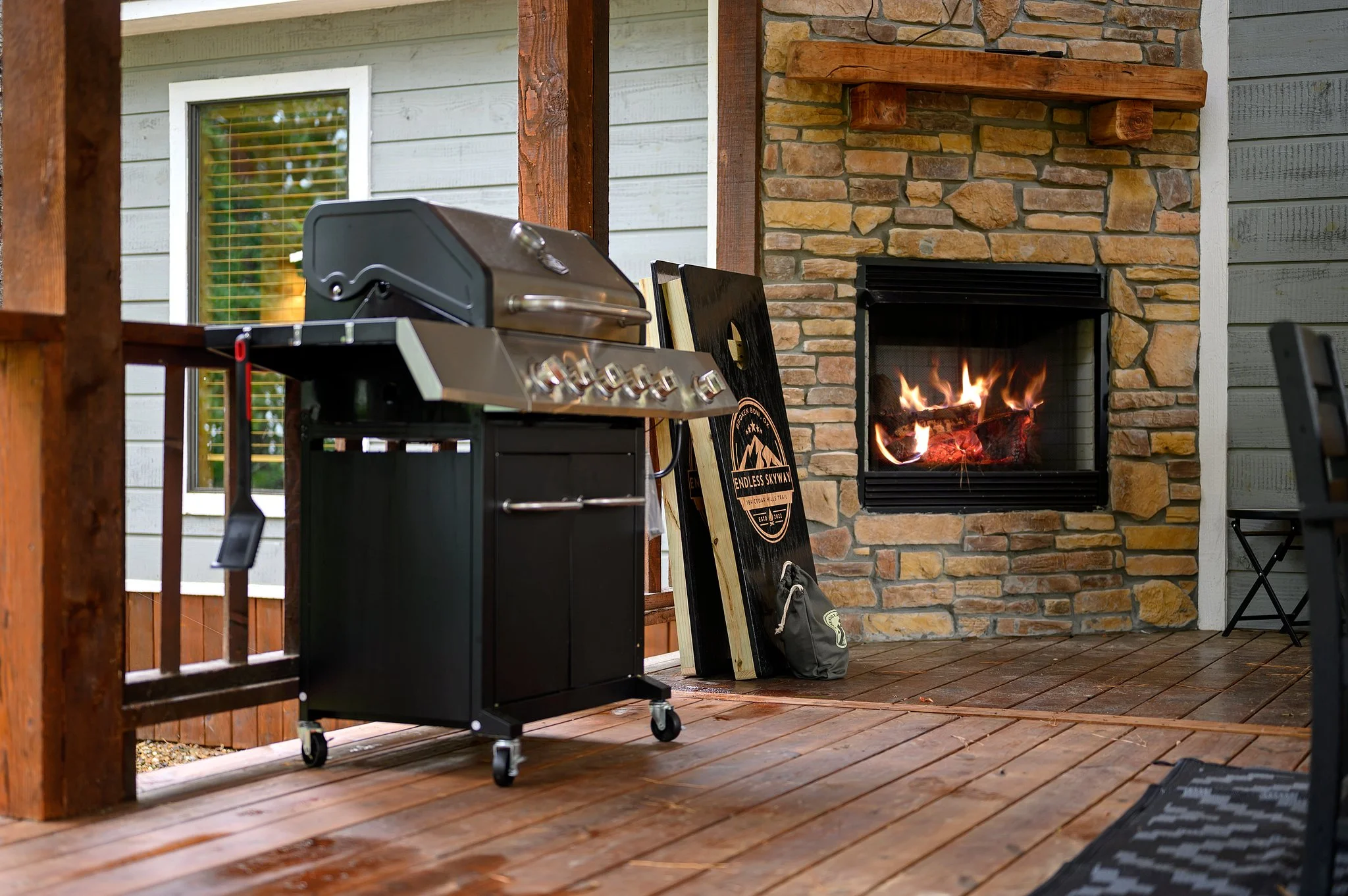 Rustic patio with grill and stone fireplace at Endless Skyway Cabin, a base for zip lining Broken Bow
